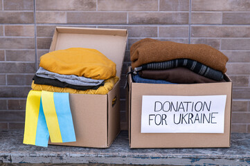 Boxes with humanitarian aid for Ukrainian refugees on the street. Ukrainian symbols, boxes with...