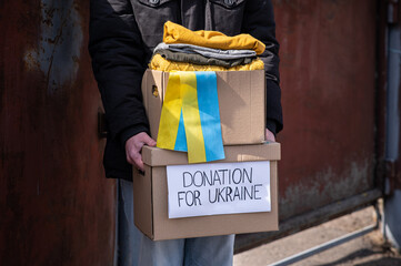 Close up of volunteer carrying box with Humanitarian aid for Ukrainian refugees in street