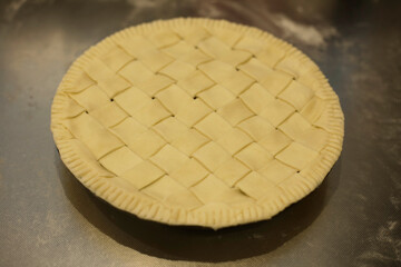 Homemade apple pie on the stainless steel kitchen board. Making apple pie.