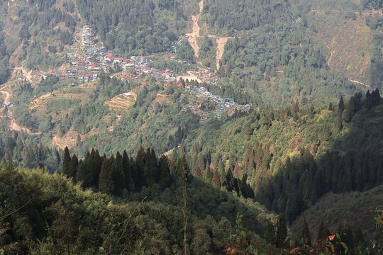 forest covered himalayan foothills and mountain village mane bhanjang from simana basti view point, at nepal india border, darjeeling, west bengal, india