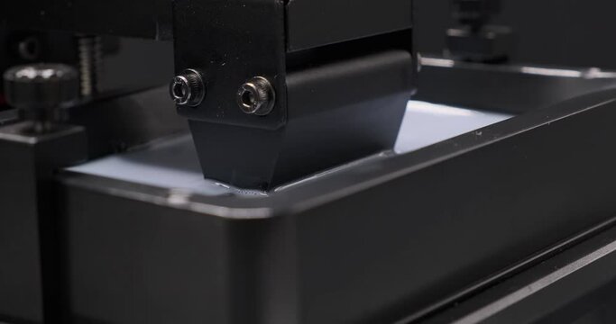 Resin MSLA 3D Printer Close up shot of  build platfrom moving up and down in resin vat during resin 3d printing. 