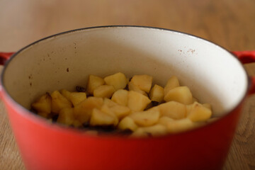  Cut up apples and raisins cooked in a pot. Making apple-raisins filling.