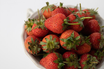 Close up Fresh organic Strawberries in a white bowl, white background