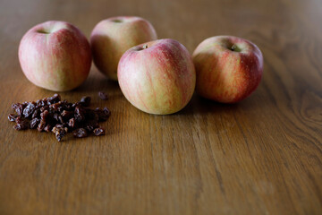 Fuji apples and raisins on wooden dining table. Space for copy.