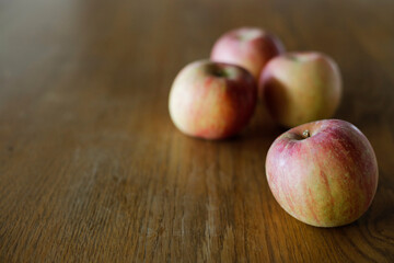 Fuji apples on wooden dining table. Space for copy.