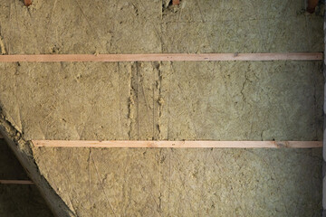 The roof is insulated with green mineral wool. Horizontal laying of insulation transverse to the first layer