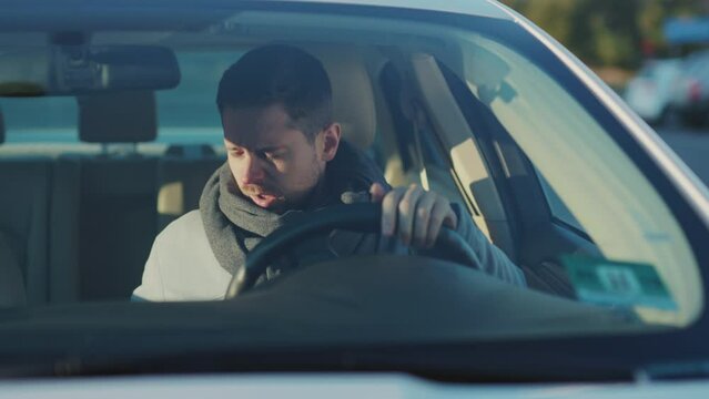 Caucasian bearded sick man sitting in car coughing cold sneezing allergy into paper napking driving work. Illness. Healthcare concept.