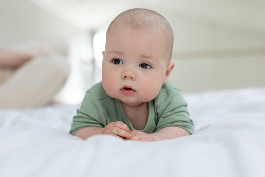 The baby lies on the bed. Little baby. High quality photo