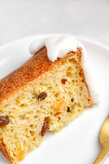 Close up Festive Easter cakes with white glaze, dried fruits and raisins with on white plate.