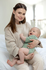 Fototapeta na wymiar Mom and baby. Beautiful woman with a baby at home. High quality photo