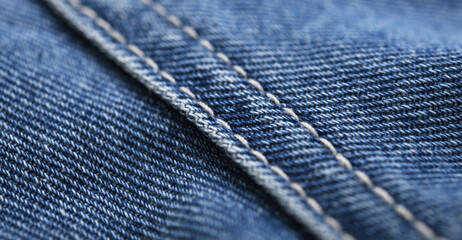 Old blue jeans background and texture close up.Denim seam. 