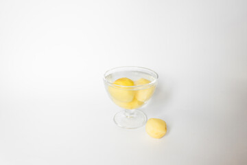 Glass bowl of water with raw peeled potato vegetables. Isolated on white background.