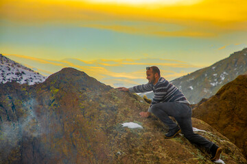 A man doing mountain sports at sunset