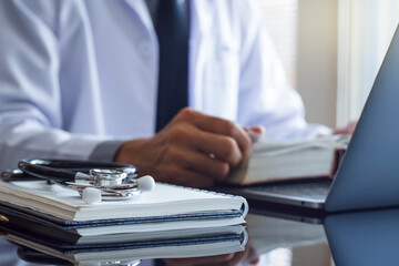 Male doctor or medical student reading book