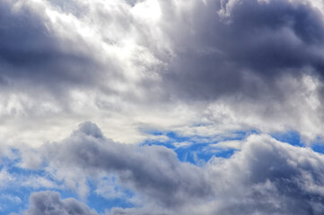 Fototapeta premium Blue sky with cumulus clouds. The clouds are gray, blue and white. In the shape of a crocodile. Backgrounds. Details. 