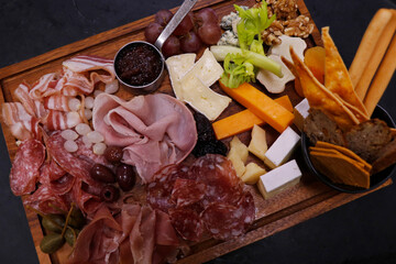 assorted cheese and cold meat platter with condiments