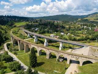 Fototapeta premium Old railway bridge in the mountains. Ukrainian Carpathians. Aerial drone view.
