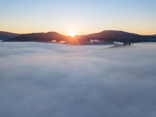 Sunrise over the fog in the Ukrainian Carpathians. Aerial drone view.