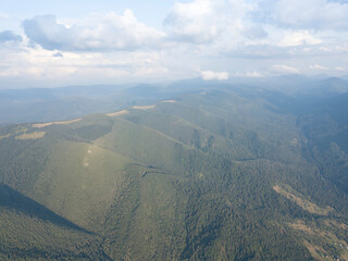 Obraz premium Green slopes of Ukrainian Carpathian mountains in summer. Cloudy day, low clouds. Aerial drone view.