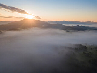 Sunrise over the fog in the Ukrainian Carpathians. Aerial drone view.