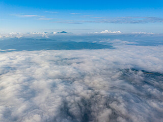 High flight above the clouds in the mountains. Aerial drone view.