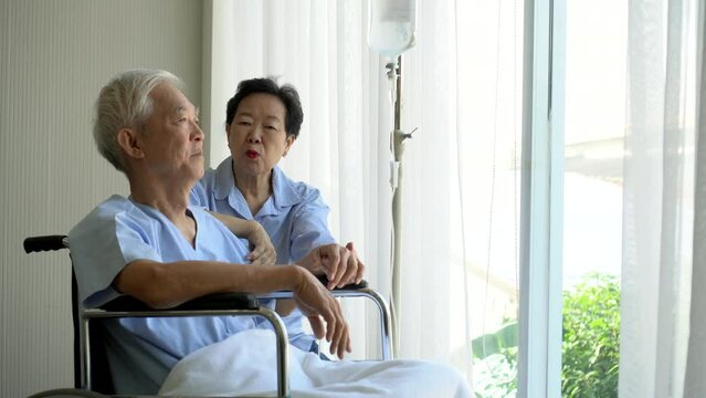 Old Asian senior elder couple on wheel chair talking sharing having coversation