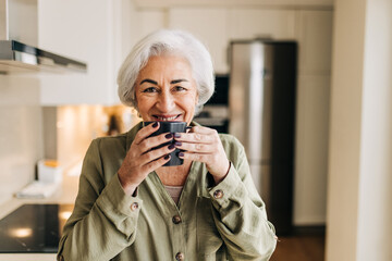 Happy senior woman starting her day with a cup of coffee