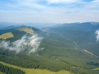 Green mountains of Ukrainian Carpathians in summer. Sunny day, rare clouds. Aerial drone view.