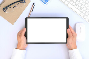 Top view image of white workspace is surrounding by a white blank screen tablet and various equipment