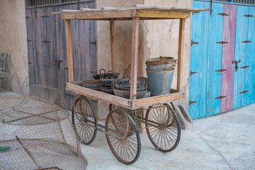 a cart with buckets stands near a house in the old town