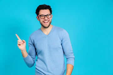 Fototapeta premium Smiling Laughing Positive Confident Caucasian Handsome Brunet Man While Looking Straight To Side Against Blue Background.