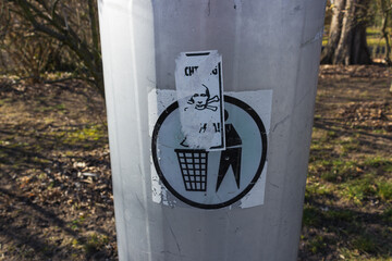 Sticker of russian terrorist putin on the modern trash can for waste in the europe park. Stop war...