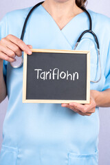 Krankenschwester oder Altenpflegerin zeigt auf eine Tafel auf der Tariflohn steht