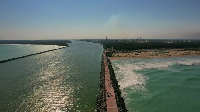 Aerial view of long breakwater of Tampico beach with walking people