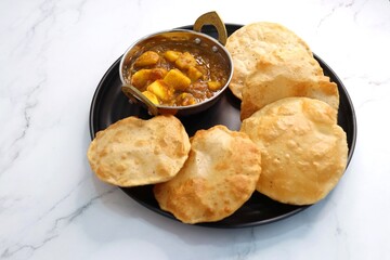 Indian cuisine - Puri Bhaji. It is a traditional breakfast dish in North India. Puri is a deep fried bread made from whole wheat flour and Served with spicy Potato curry called bhaji or alu ki sabji.