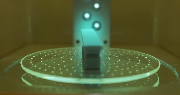 Close up 3D printing object text being cure in resin curing station, Post processing of consumer resin 3D printing. 