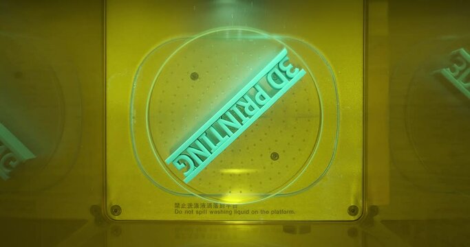 Bird eye view top angle 3D printing object text being cure in resin curing station, Post processing of consumer resin 3D printing. 