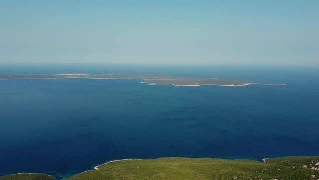 aerial of Croatian island Unije seen from Losinj island, flying right