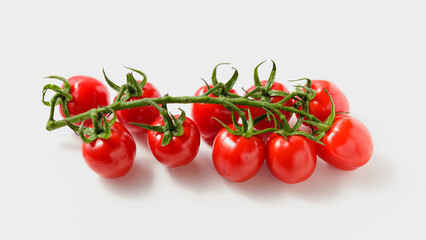 Cherry tomatoes on branch on white background.