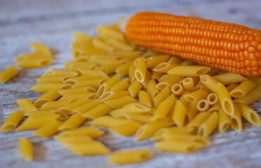 penne di pasta italiana e una pannocchia di grano maturo