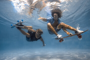 Men skateboarding underwater in the swimming pool