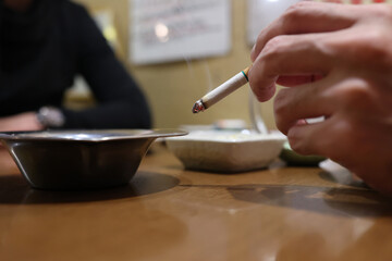 Fototapeta na wymiar 友達と話しながらタバコを吸う人物の手元