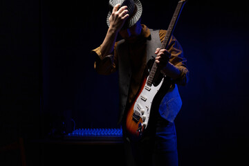 Obraz premium Man playing electric guitar. Musician at record studio holding electric guitar
