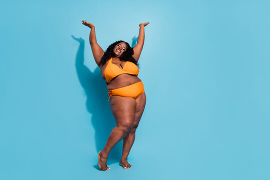 Full length photo of large oversize lady enjoy dance conscious love body raise hands up isolated over blue color background
