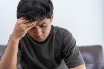 Fototapeta premium Depression and mental illness. Asian man disappointed, sad,cry after receive bad news. Stressed man confused with problems, arguing with girlfriend, worry about unexpected pregnancy of girlfriend.