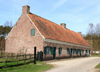 old farmhouse with green windows in a rural landscape