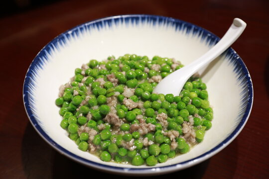 Green mince peas in a bowl with a spoon