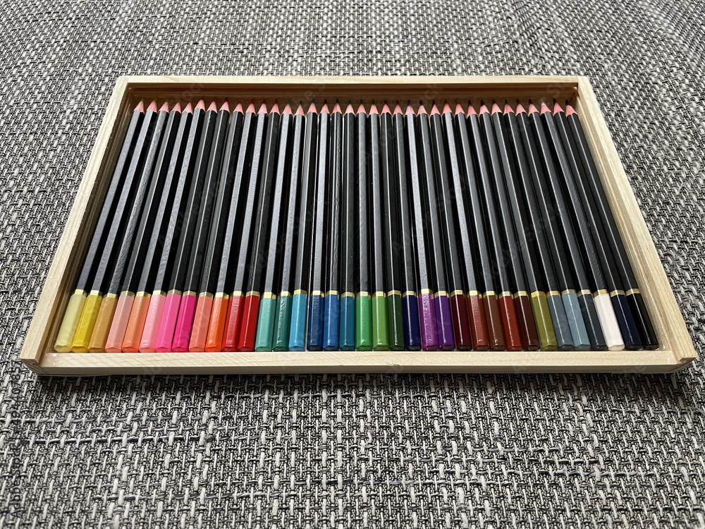 Wall mural different colored crayons arranged in a wooden box.