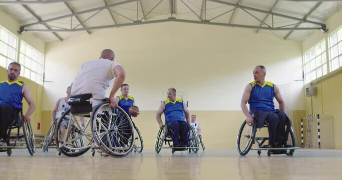 Persons with disabilities playing basketball in the modern hall. Slow motion 
