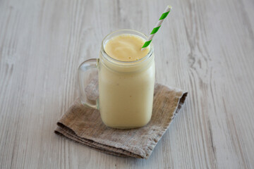 Homemade Pineapple Mango Banana Smoothie in a Glass Jar, low angle view.